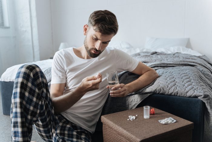 unhappy man taking pills