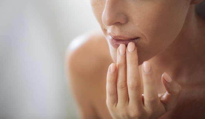 woman touching her lips.