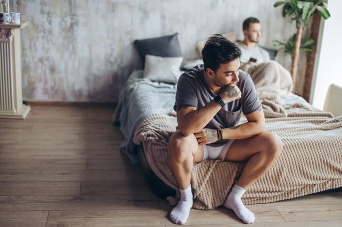 Young gay couple in quarrel at home. LGBT and same- sex relationship concept