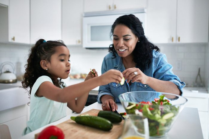 mother and daughter preparing healthy food salad