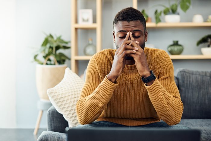 exhausted man at home with hands on his face