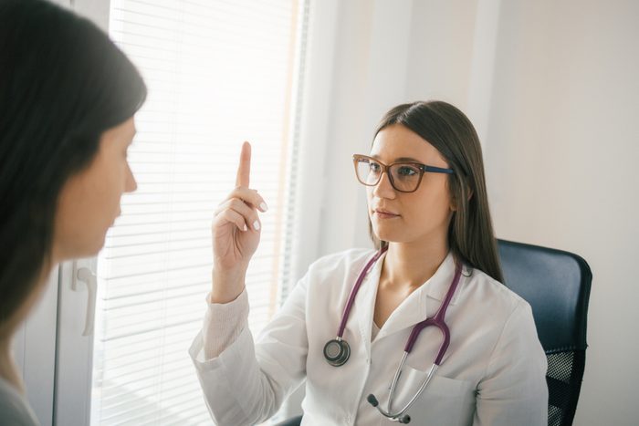 Female doctor examining a patient's eye reflex and accommodation. Medical examination, clinic, hospital