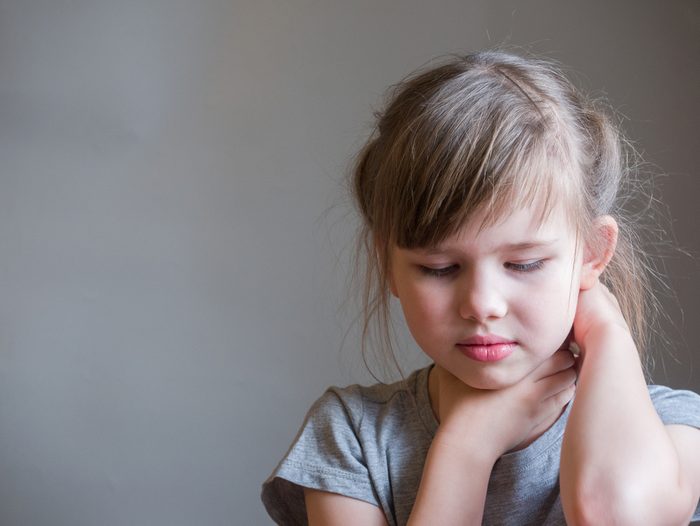 Neck pain. Portrait stressed unhappy child girl with back pain, Negative human emotions facial expression feeling.