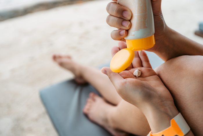squeezing sunscreen lotion into hand