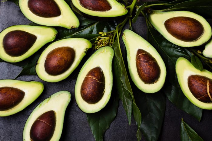 Avocado. Fresh avocado palta with leaves on black background. Guacamole ingredient. Vegetarian or healthy eating. Healthy fat