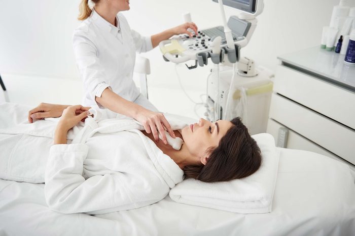 doctor administering a thyroid neck ultrasound