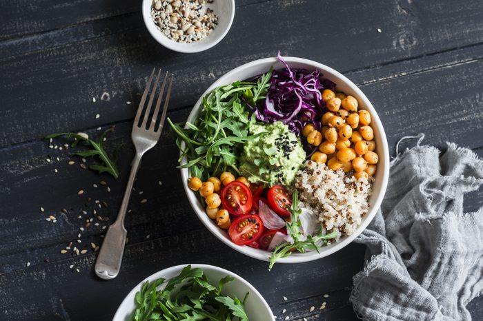 Quinoa and spicy chickpea vegetable vegetarian buddha bowl. Healthy food concept. On a dark background, top view