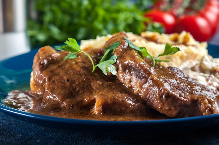 Stewed pork neck in sauce. Served with mashed potatoes and salad