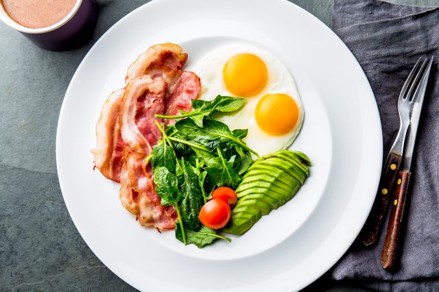 Ketogenic diet breakfast. fried egg, bacon and avocado, spinach and bulletproof coffee. Low carb high fat breakfast.