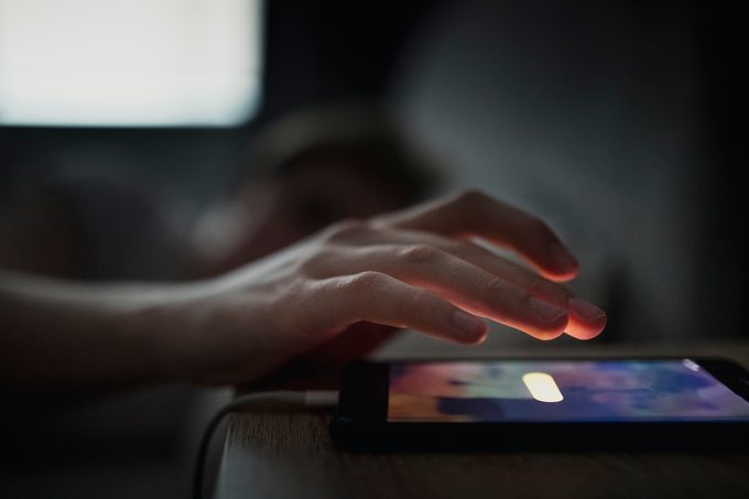 snoozing alarm clock on phone in the morning