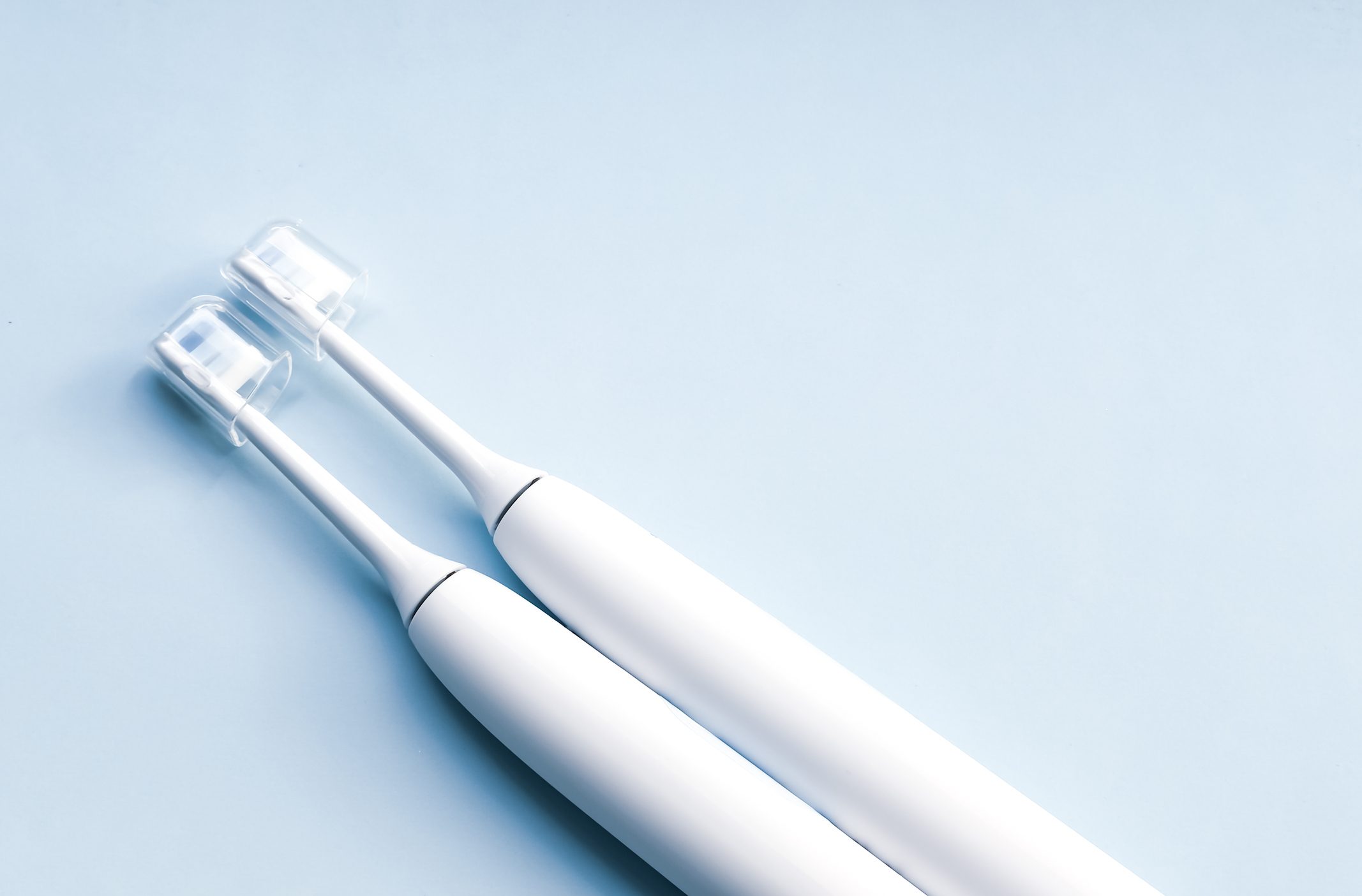 electric toothbrushes on light blue background