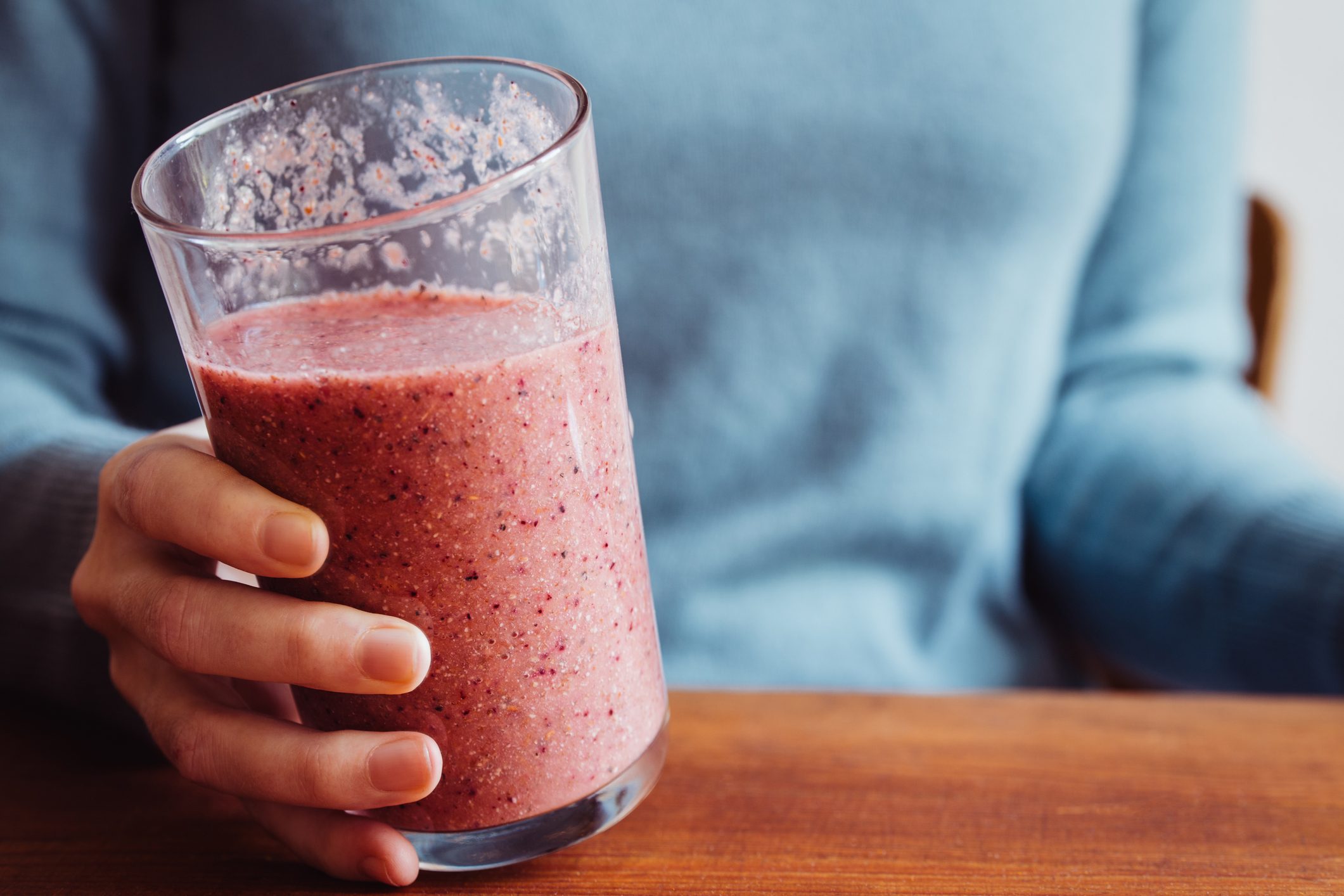 close up of woman holding a smoothie