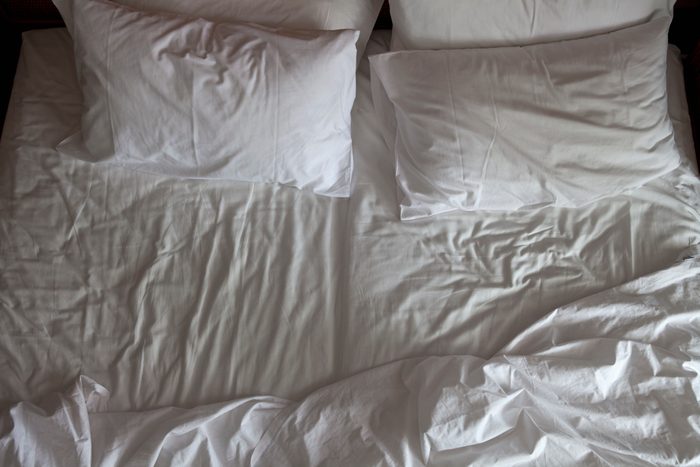 Detail of an unmade double bed