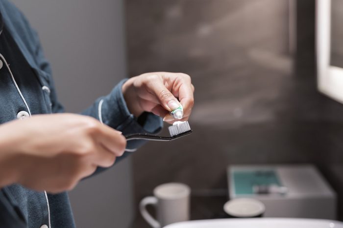 Asian woman squeezing toothpaste