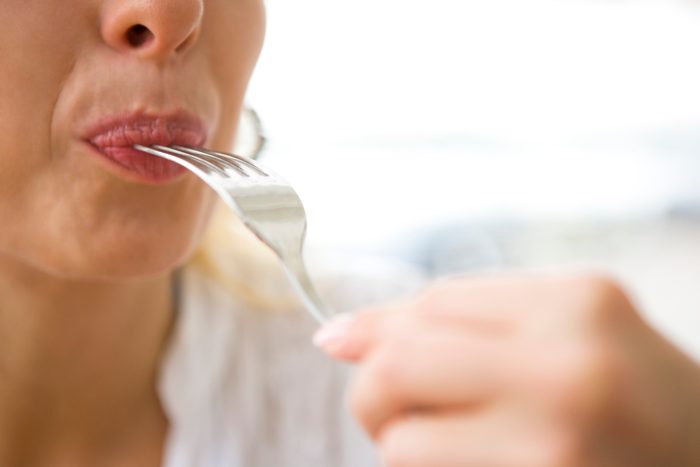 woman with metal fork in her mouth