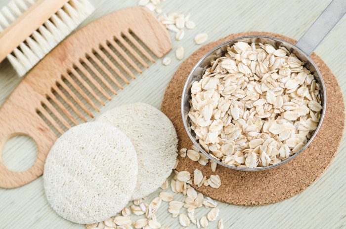 Rolled oats in a small bowl for preparing homemade facial mask and scrub. DIY oatmeal cosmetics.