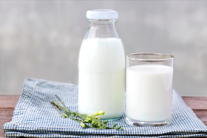 glass of milk and bottle of milk on the wood table.
