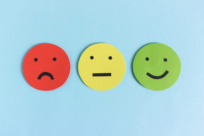 Row of three colorful smileys for expressing satisfaction, dissatisfaction and indifference composed on blue background