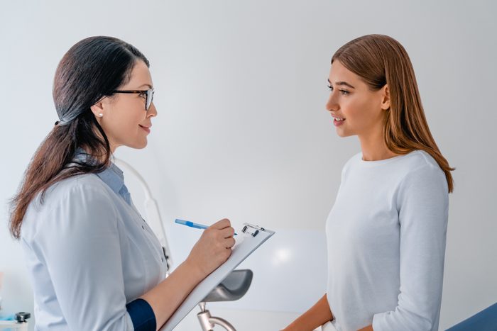 Female adult gynecologist working with patient in clinic