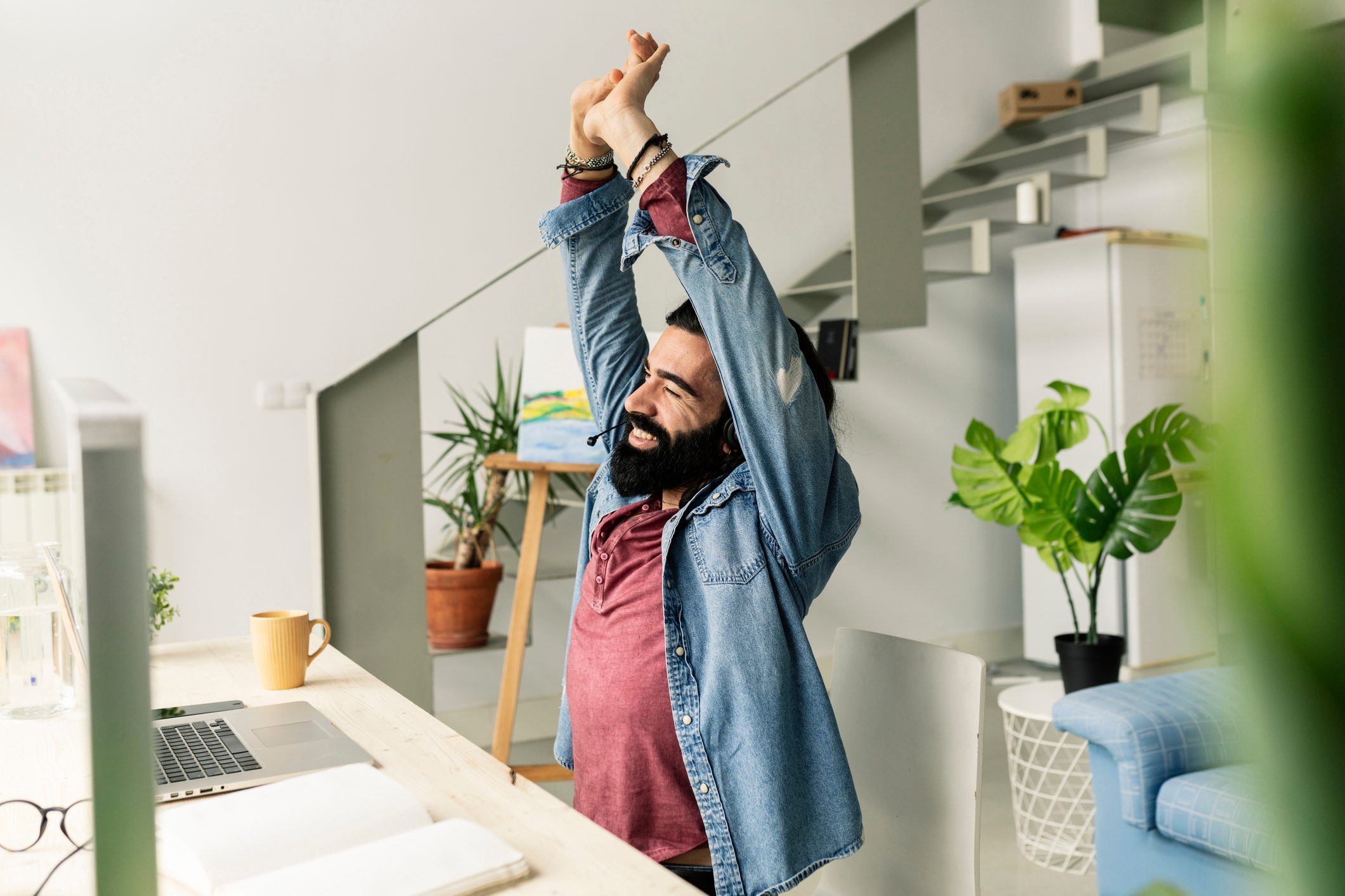 Tired Man Stretches After Working With Computer