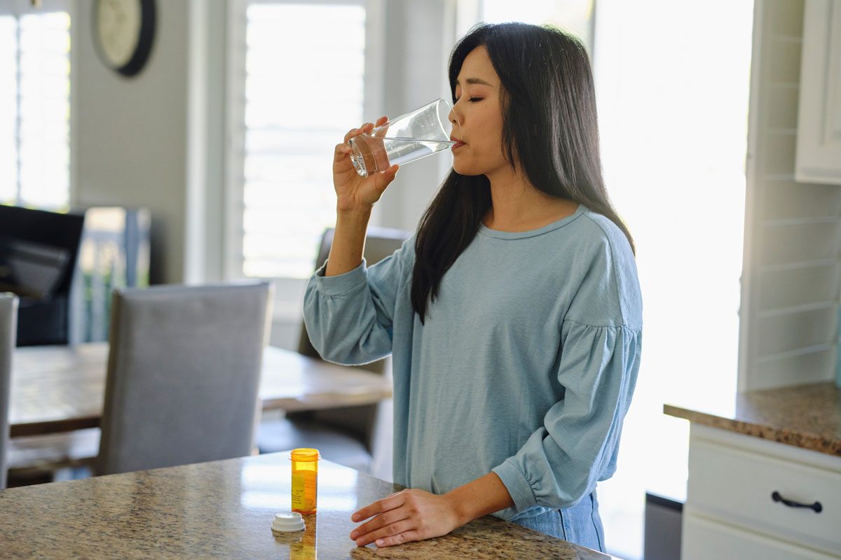 woman taking medication at home