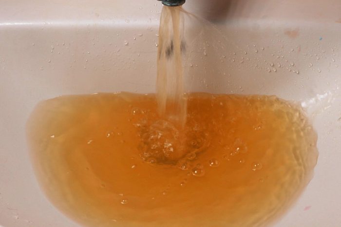 Rusty Water Pours From Tap. Water Pollution. Global Environment
