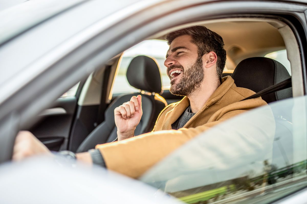 Mid Adult Man Driving A Car And Singing